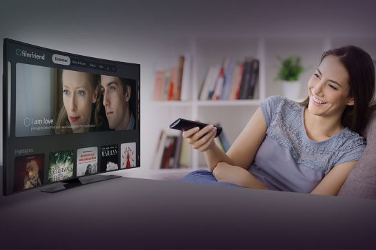 Eine Frau sieht auf Ihr TV-Gerät (C) filmfriend