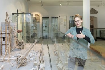 Fotografie: Dr. Alexandra Brack erklärt Ausstellungsstücke.