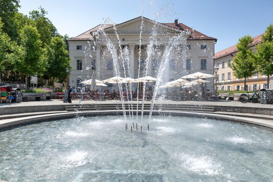 Brunnen am Regensburger Bismacrkplatz. Wasserfontänen und Blauer Himmel