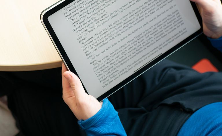 Fotografie - Eine Frau liest ein eBook auf einem Tablet