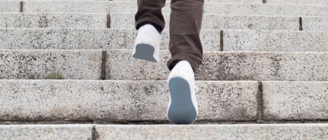 Bildausschnitt Schuhe von Person, die Treppe hinaufgeht