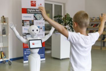 Fotografie: Charlie und ein Kind recken die Arme nach oben