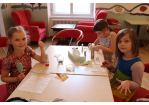 Drei Kinder sitzen um einen Tisch, kämmen sich die Haare und lackieren sich die Fingernägel. (C) Stadt Regensburg, Amt für kommunale Jugendarbeit