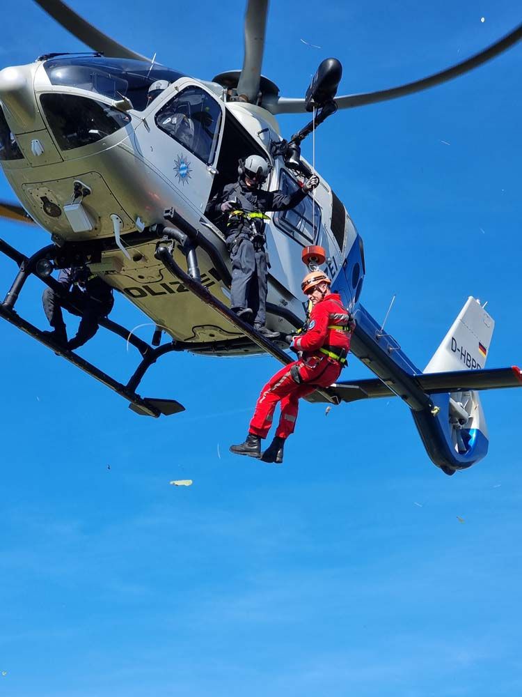 Fotografie: Höhenretter der Berufsfeuerwehr Regensburg an der Winde eines Hubschraubers.