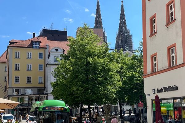 Fotografie - Fußgänger flanieren am Kohlenmarkt, während ein Elektrobus vorbeifährt