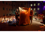 Fotografie: Die Künstler Siegfried und Roy spannen ein Tuch vom Boden nach oben. Im Hintergrund jubelt das Publikum.