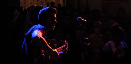 Konzert der Band "Polite Sleeper" im W1 - Zentrum für junge Kultur. Blick von der Bühne ins Publikum, im Vordergrund der Sänger und Gitarrist der Band im Scheinwerferlicht.