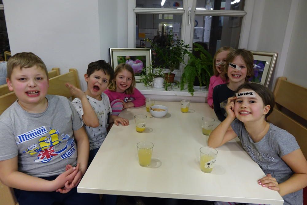 Sechs Kinder sitzen an einem Tisch. Im Kinderhotel