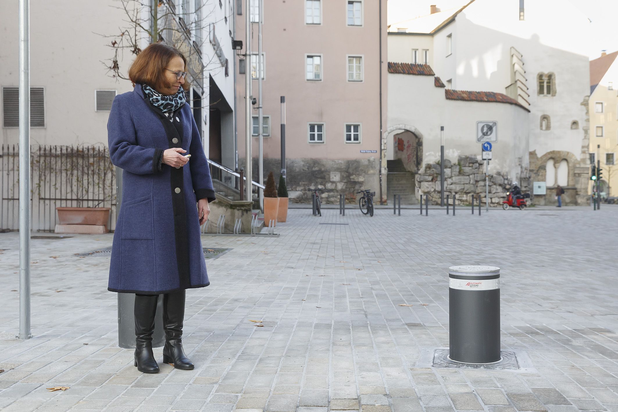 Fotografie: Oberbürgermeisterin Gertrud Maltz-Schwarzfischer senkt den Poller mit Hilfe eines Handsenders ab. 