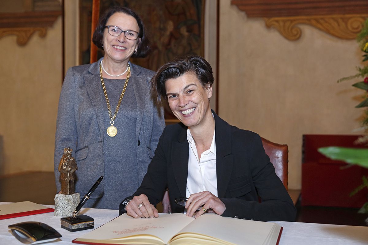 Verleihung des Brückenpreises 2019 - Die Preisträgerin Dr. phil. Carolin Emcke trägt sich ins Gästebuch der Stadt Regensburg ein. Links im Bild Bürgermeisterin Gertrud Maltz-Schwarzfischer