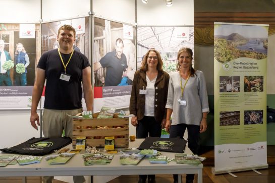 Fotografie: Elke Oelkers mit Kollegin und Kollege an einem Stand zur Öko-Modellregion am Tag der offenen Tür