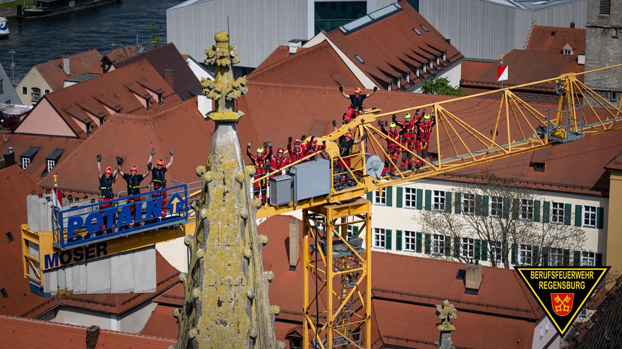 Teilnehmer stehen auf einem Baukran
