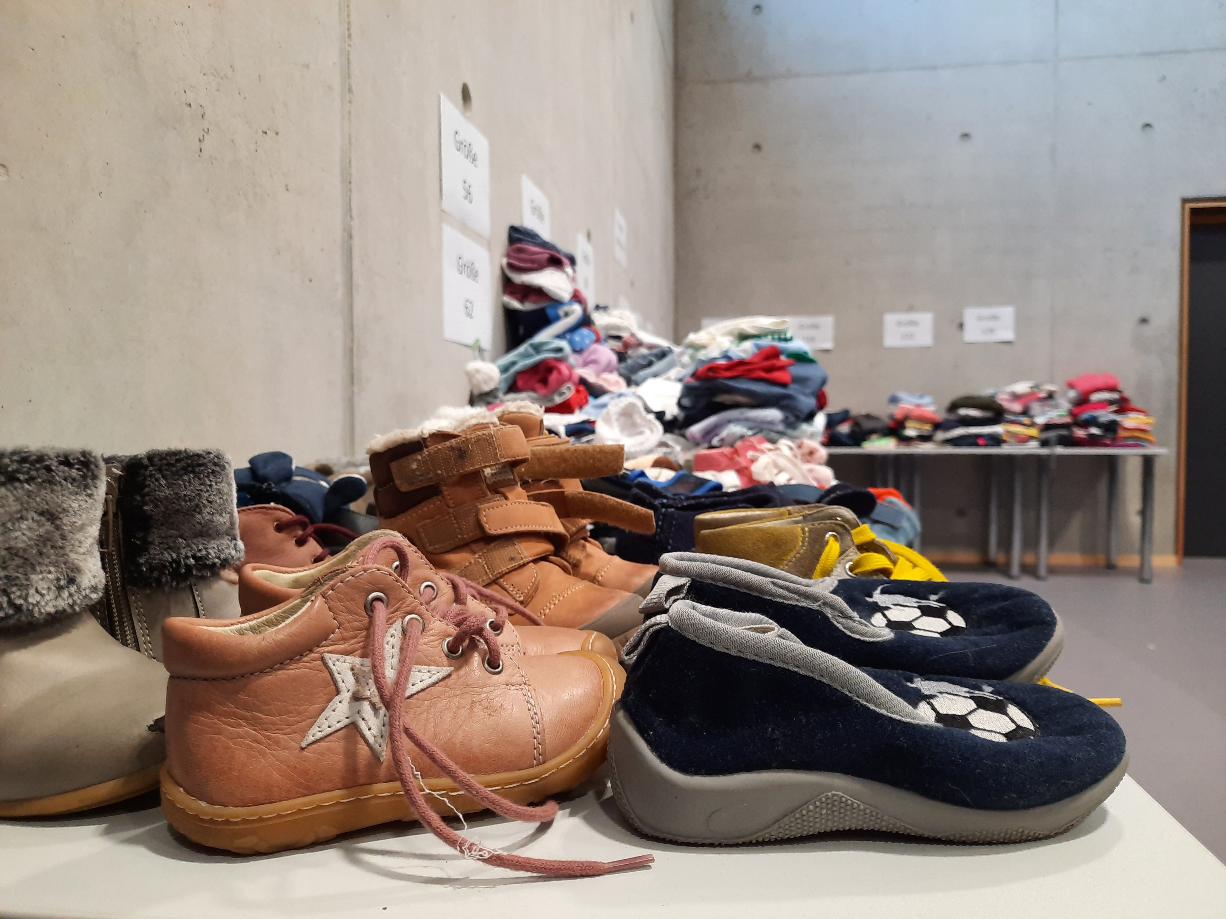 Fotografie - Tisch mit braunen und blauen Babyschuhen darauf