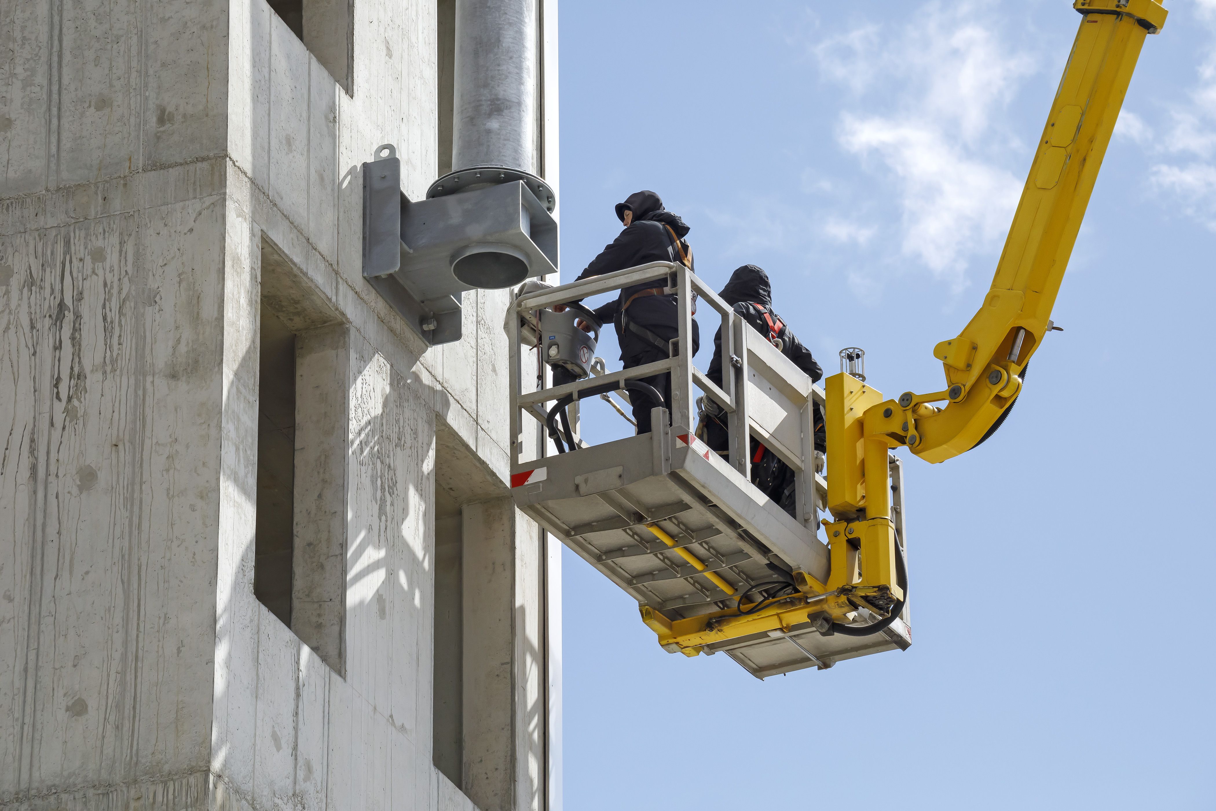 Fotografie - Montage des Funkmastes am Schlauchturm - zwei Männer in einer Hebebühne während der Montage