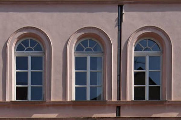 Reihe von Fenstern an rosa Hauswand