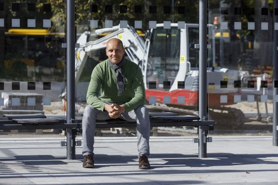Fotografie: Aaron Tonndorf sitzt auf einer Wartebank am Interims-ZOB. © Bilddokumentation Stadt Regensburg