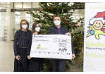Fotografie - drei Personen mit einem Spendenscheck vor einem Weihnachtsbaum (C) Bilddokumentation Stadt Regensburg