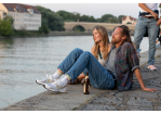 Fotografie: Eine Frau und ein Mann sitzen auf dem Weg an der Donau.
