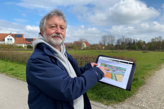 Fotografie: Stadtheimatpfleger Dr. Gerhard Waldherr zeigt vor dem Gelände der Villa Rustica die Lage der Gebäude. 