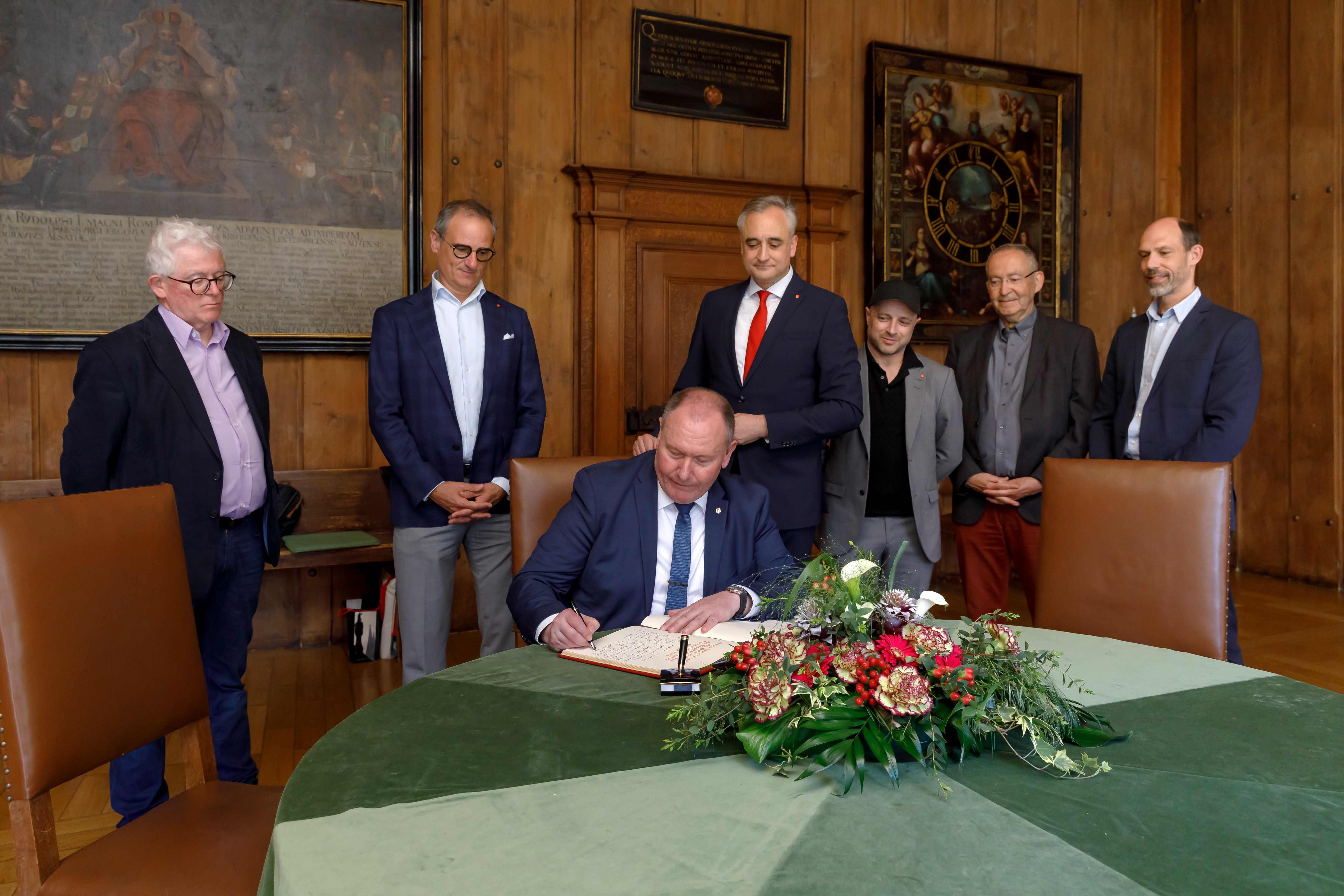 Fotografie – Gästebucheintrag des Botschafters (v. l. n. r.) Sprecher des Direktoriums des Europaeums Prof. Dr. Ger Duijzings, Kulturreferent Wolfgang Dersch, Botschafter Ciocoi, Stadtrat Dr. Thomas Burger, Stadtrat Alexander Irmisch, Klemens Unger, Personal- und Verwaltungsreferent Dr. Patrick Veit