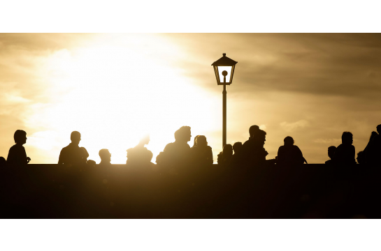 Themenbild Leben in Regensburg - Personen im Sonnenuntergang auf der Steinernen Brücke