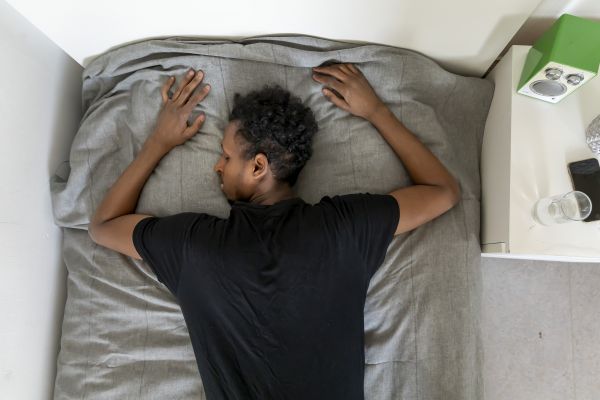 Jugendlicher liegt auf dem Bett