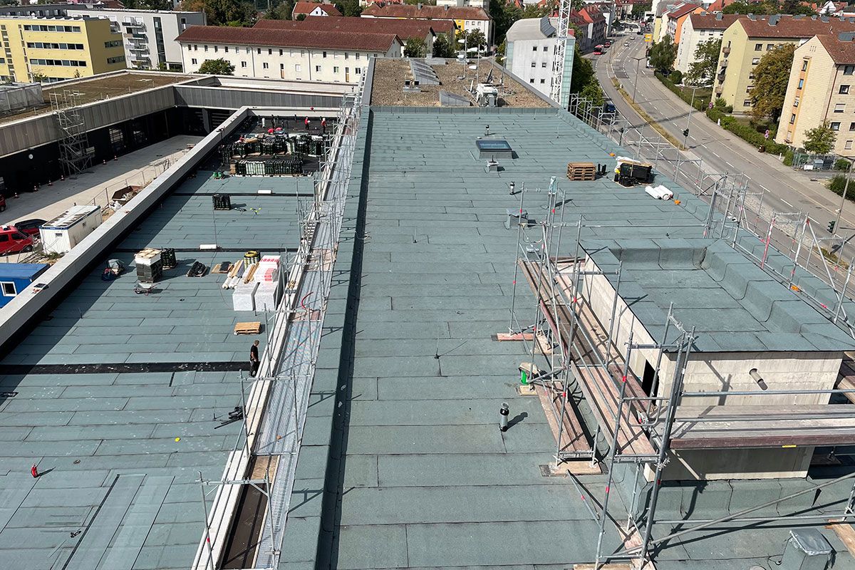 Fotografie - Blick aus dem 5. OG auf den Bauabschnitt 3b. Das Dach wurde mit Teerbahnen verschweißt. Auf dem Dach der Fahrzeughalle entsteht später eine Dachterrasse mit Aufenthaltsmöglichkeit für die Mannschaft.
