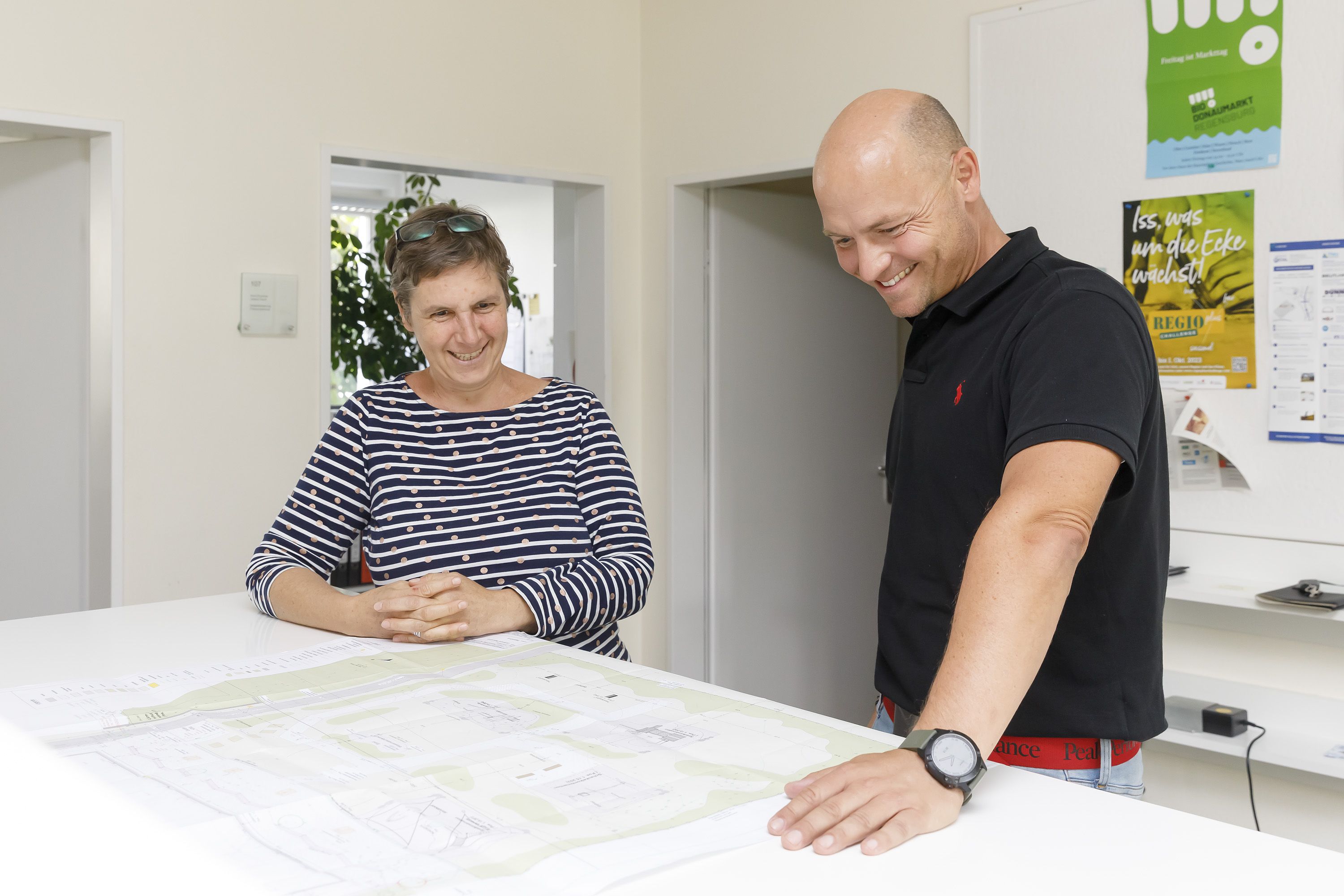Fotografie: Michael Daschner bespricht mit seiner Mitarbeiterin, der Landschaftsarchitektin Doris Drummer, die Pläne für die Außenanlagen eines Jugendbegegnungszentrums.