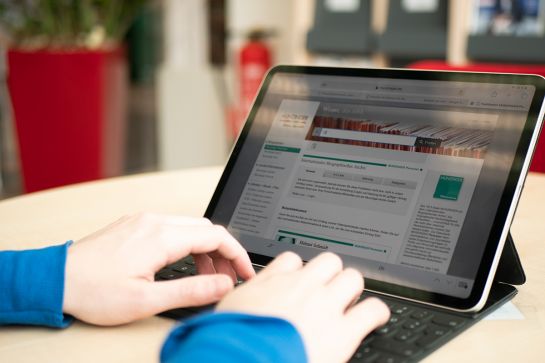 Fotografie - Eine Person surft in der Datenbank von Munzinger.