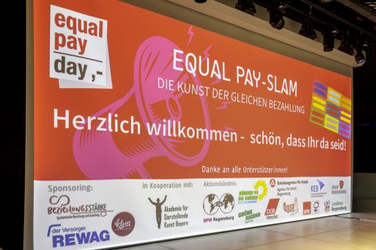 Fotografie: Leinwand mit Begrüßung zum Equal Pay-Slam (C) Bilddokumentation Stadt Regensburg
