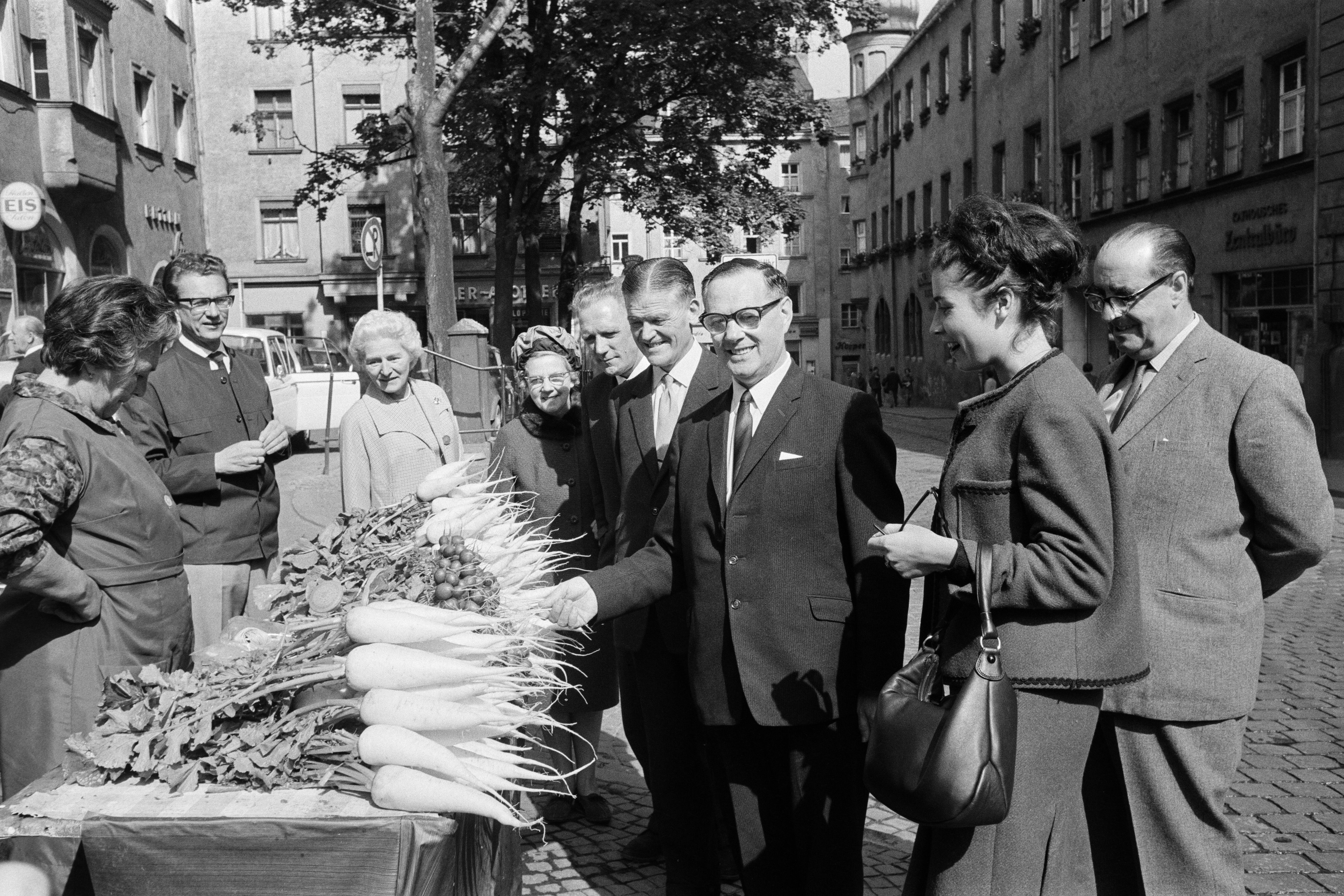 Fotografie: September 1965: Eine schottische Delegation besucht am Krauterermarkt einen traditionellen Radi-Stand. 