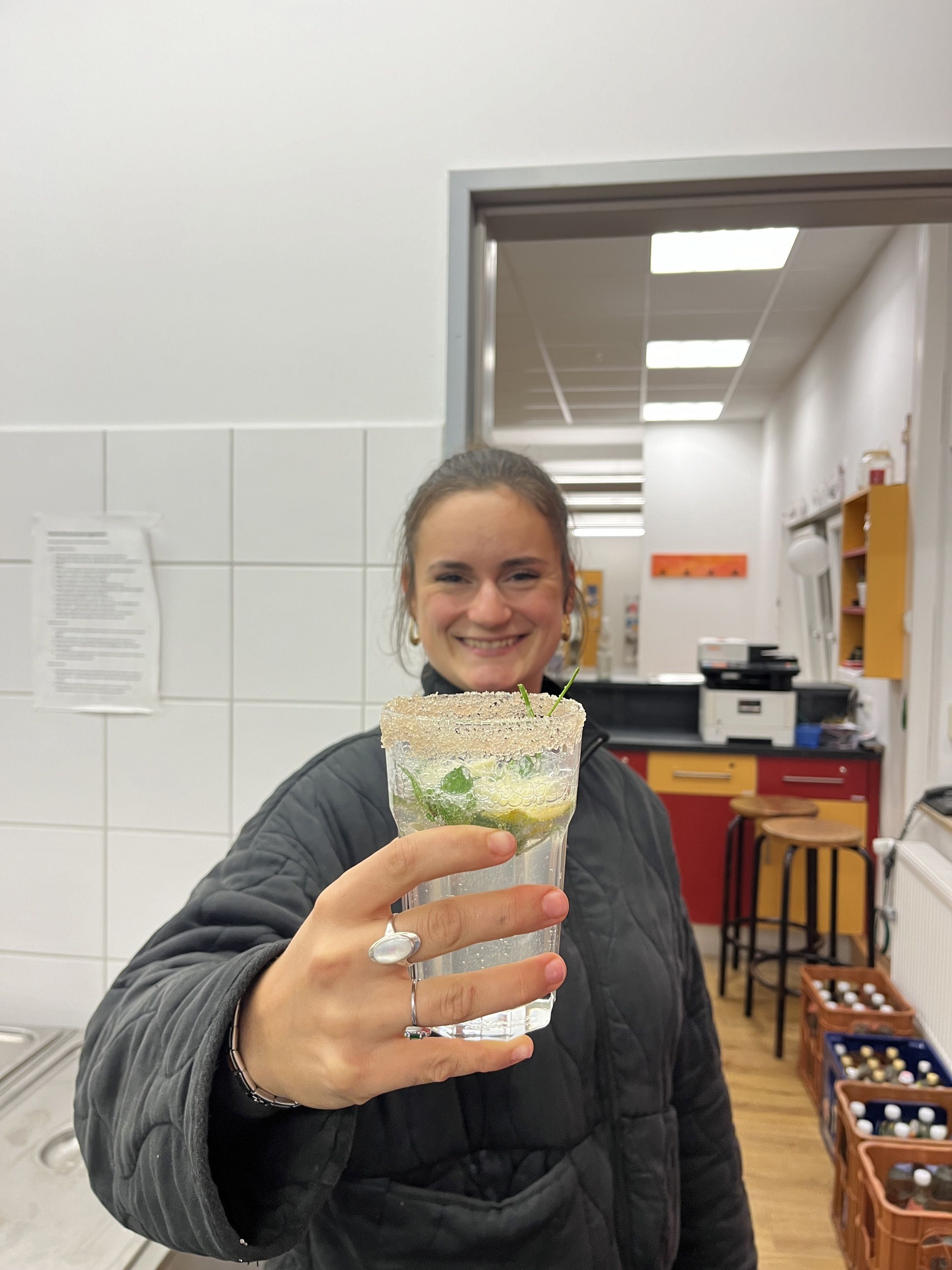 Eine junge Frau hält einen Cocktail in der Hand 