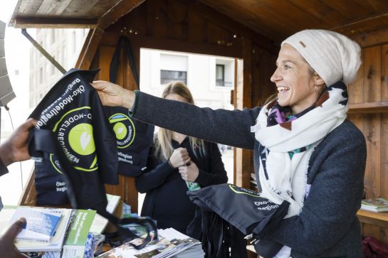 Fotografie: Elke Oelkers verteilt Stofftaschen in einem Stand am BioRegioMarkt. (C) Bilddokumentation Stadt Regensburg