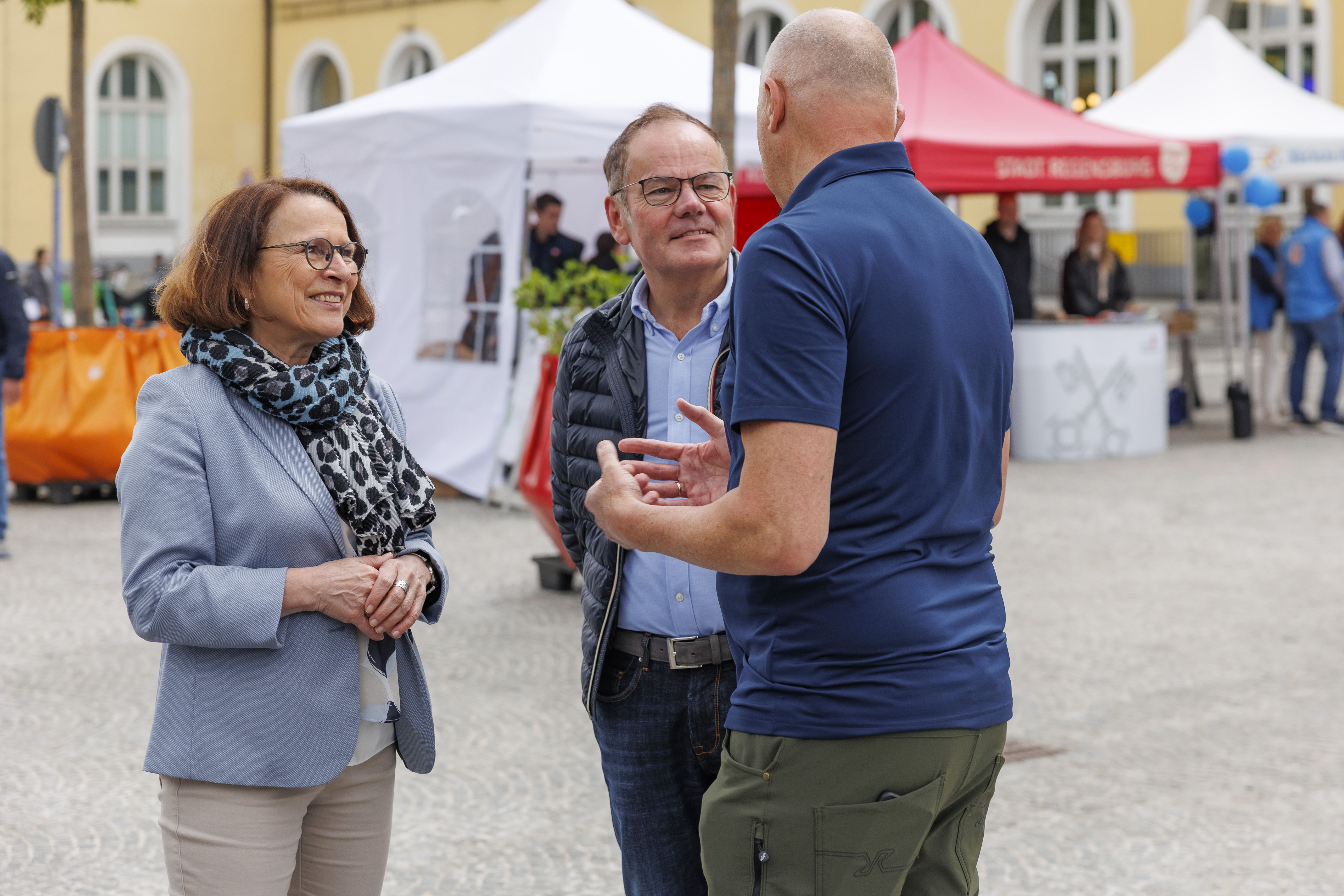 Oberbürgermeisterin Gertrud Maltz-Schwarzfischer, Stadtrat Christian Janele und Walter Reichenberger, Leiter des Bahnhofsmanagements Regensburg, begrüßen Besucherinnen und Besucher auf dem neu gestalteten Bahnhofsvorplatz 