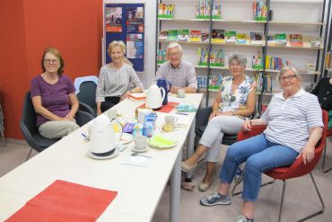 Fünf Menschen sitzen um einen Tisch