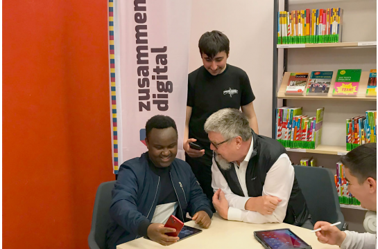 Fotografie: Ein junger Mann berät einen älteren Herren.