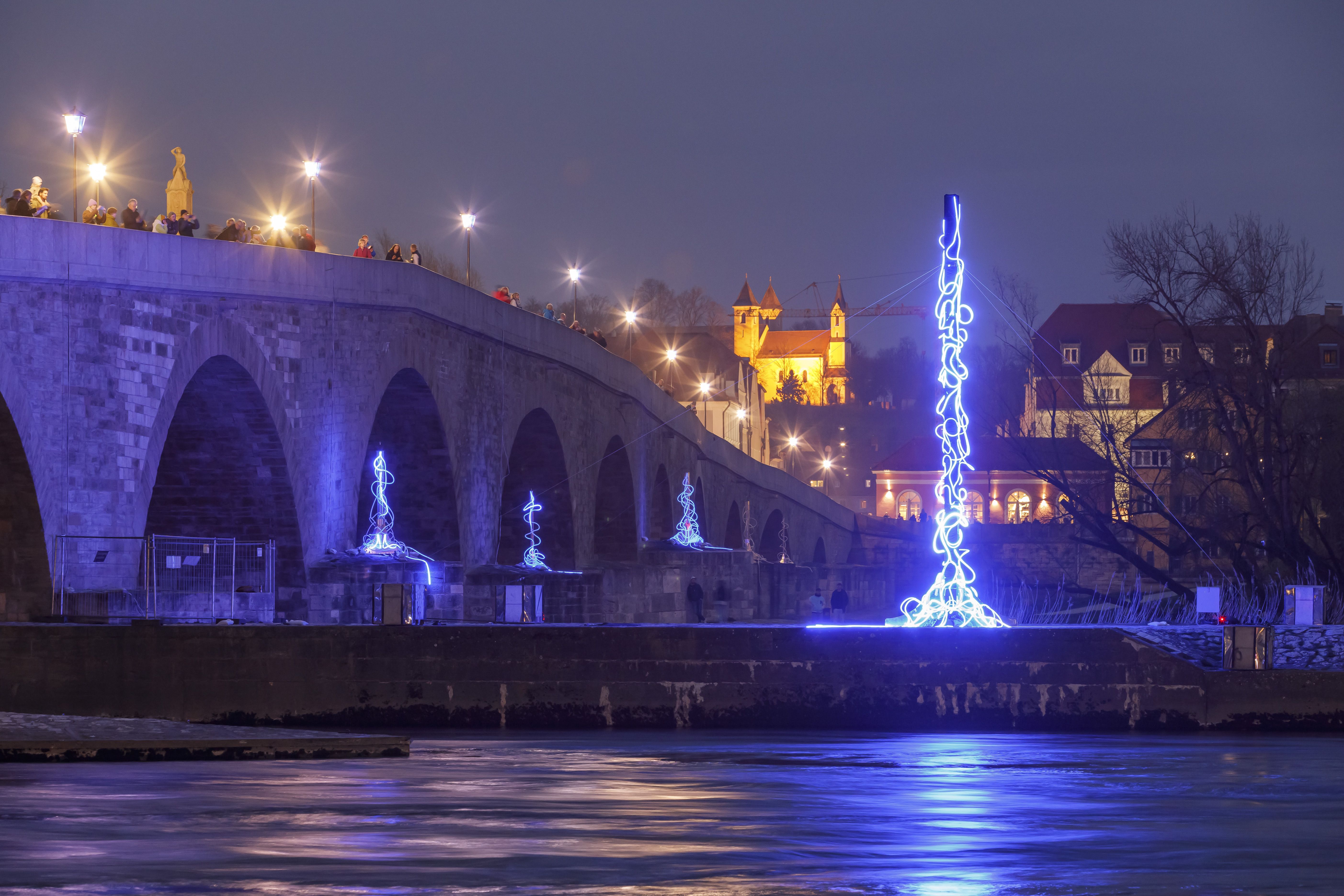 Das Kunstwerk beleuchtet die Steinerne Brücke.