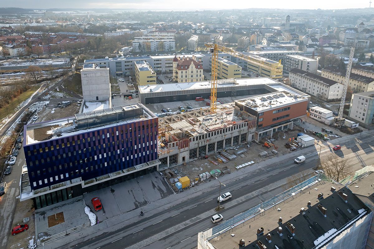 Fotografie - Blick Richtung Süden auf das gesamte Baustellengelände; im Vordergrund der Rohbau der Fahrzeughalle zwischen dem Altbau (rechts) und dem Neubau (links)