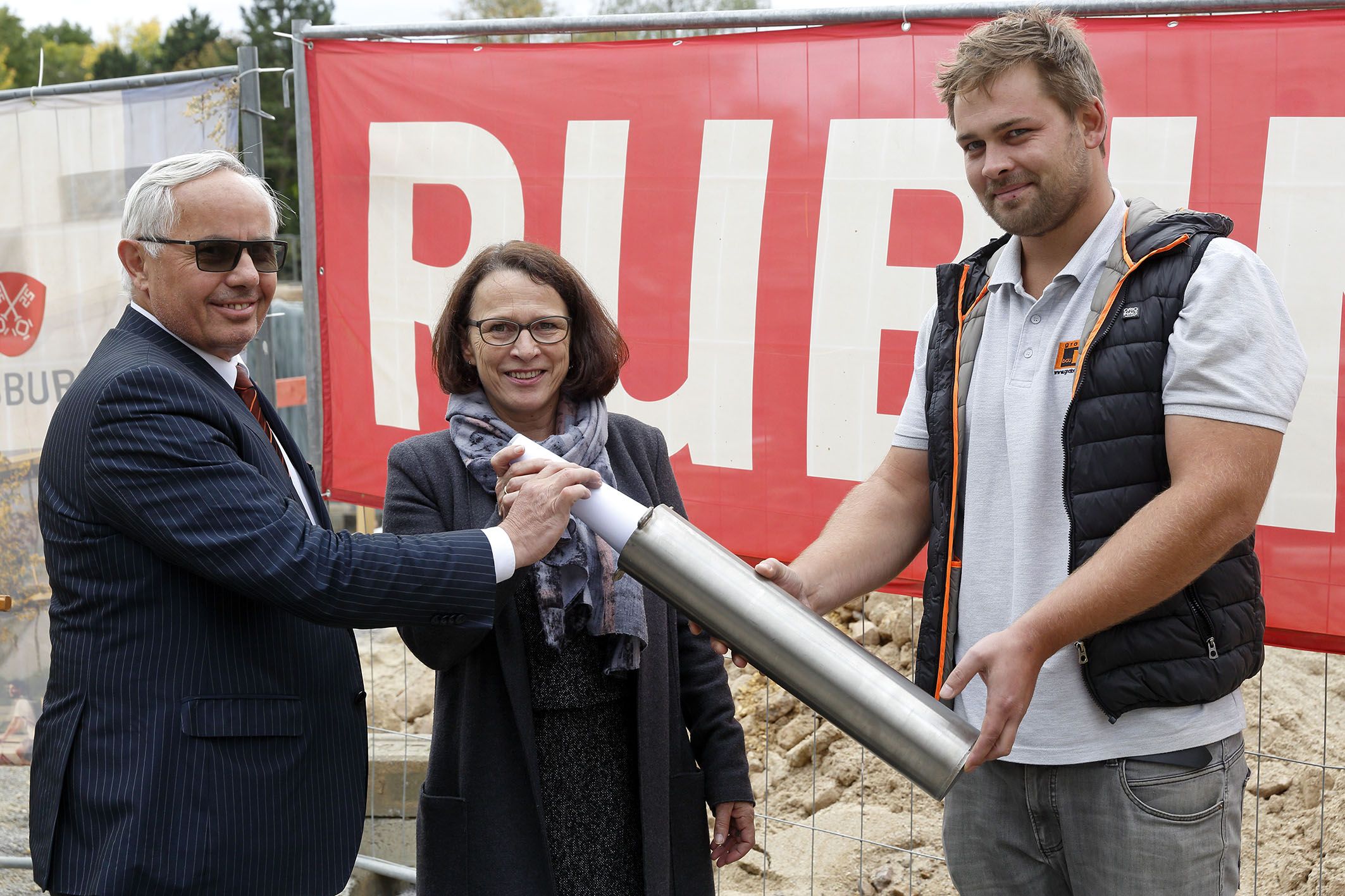 Fotografie: Bürgermeisterin Maltz-Schwarzfischer und Bürgermeister Huber legen die Urkunde zu den Rahmenbedingungen der Grundsteinlegung in die Zeitkapsel.