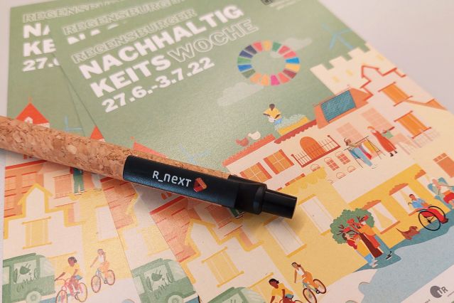 Stift mit R_NEXT Logo auf Flyer der Nachhaltigkeitswoche 2022