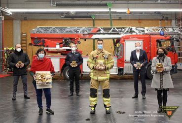 Fotografie: Bild einer Personengruppe, vor einem Drehleiterfahrzeug der Berufsfeuerwehr Regensburg.