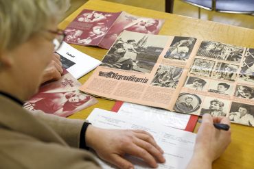 Fotografie: Martina Köglmeier studiert eine alte Zeitschrift.
