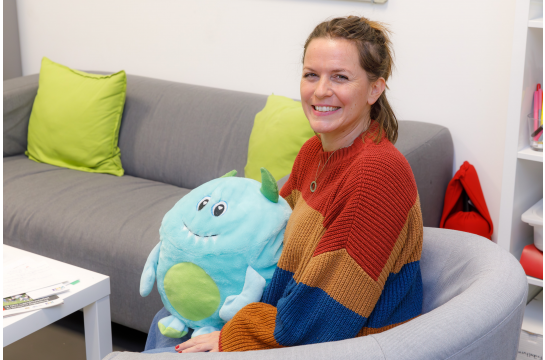 Fotografie: Anna Sonnleitner mit Kuscheltier am Beratungstisch 