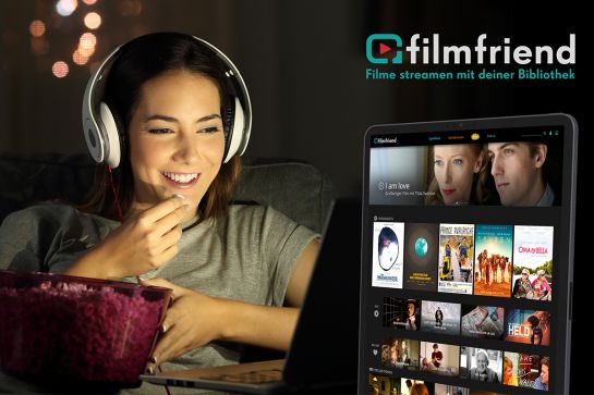 Eine Frau mit Kopfhörern schaut auf dem Tablet TV und isst Popcorn (C) filmfriend