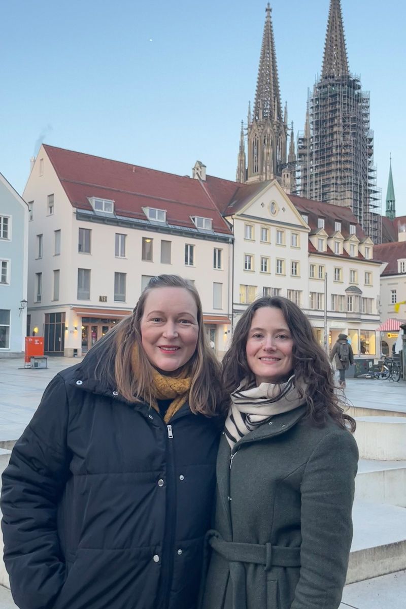 Fotografie- Agnes Gerstenberg und Lisa Hörmann auf dem Neupfarrplatz mit Dom im Hintergrund