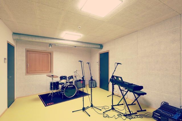 Es ist der Bandraum zusehen mit einem Schlagzeug und einem E-Piano.