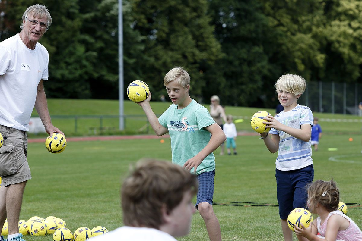 Fotografie - Kinder mit Betreuer spielen Handball