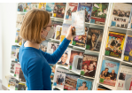 Fotografie - Eine Person stöbert durch die DVD-Auswahl in der Bücherei Nord.