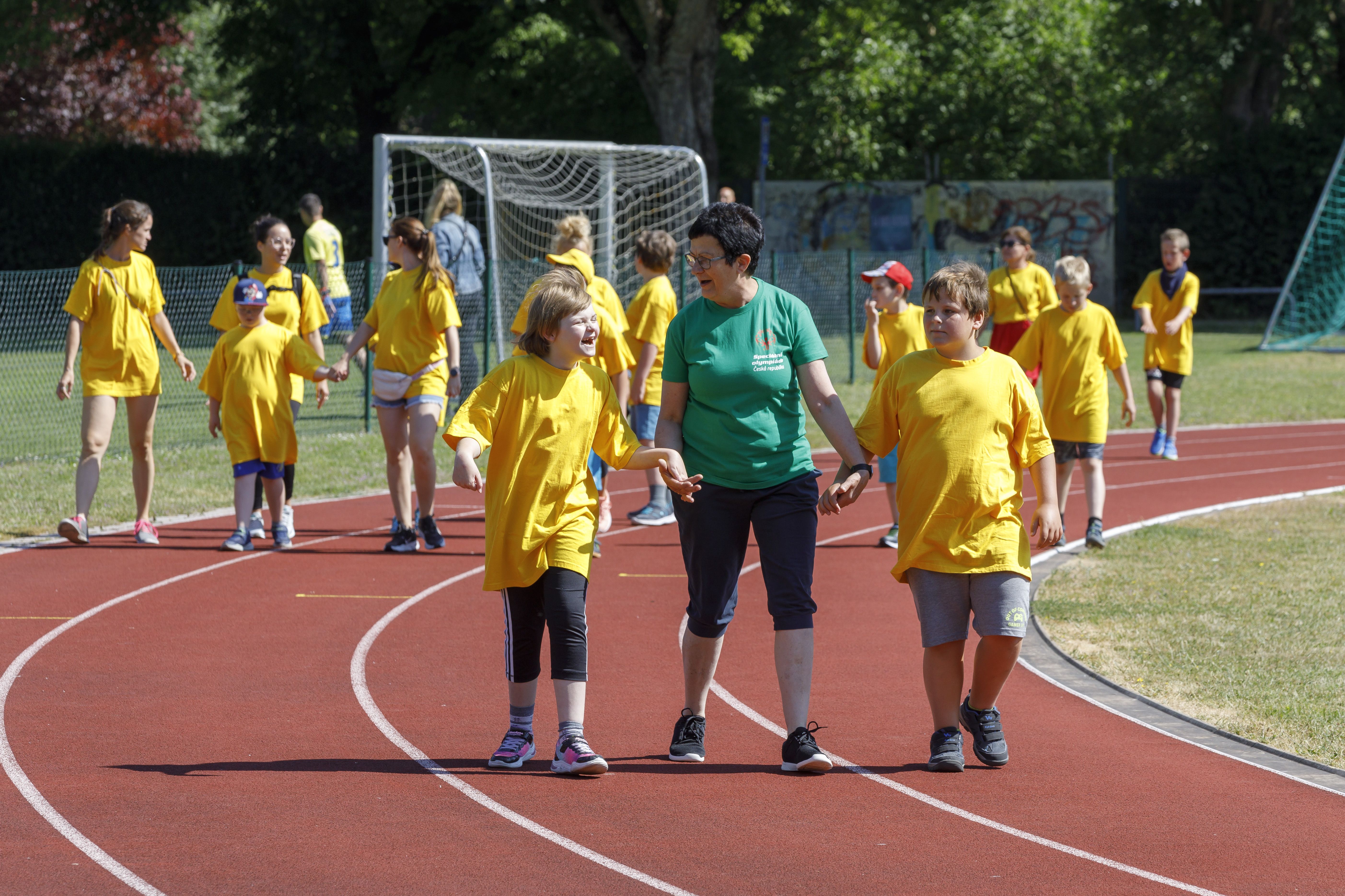 Fotografie: Junge Athletinnen und Athleten trainieren auf der Laufbahn.
