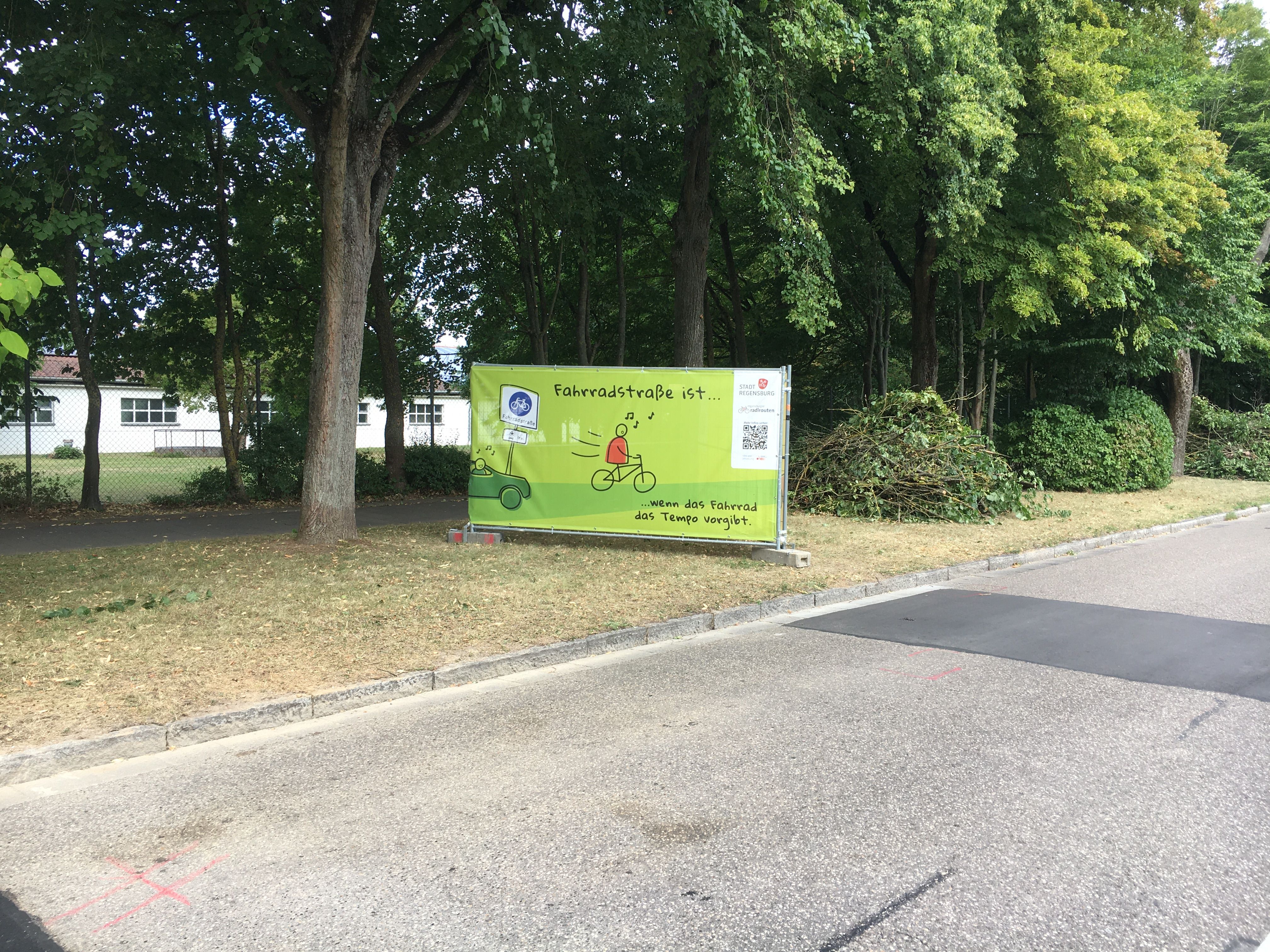 Fotografie eines grünen Banners mit dem Spruch "Fahrradstraße ist... wenn das Fahrrad das Tempo vorgibt."
